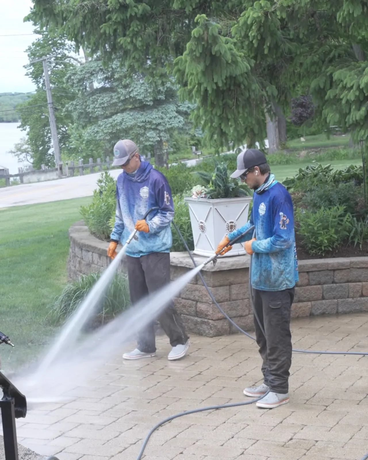 Two crew washing a stone wall