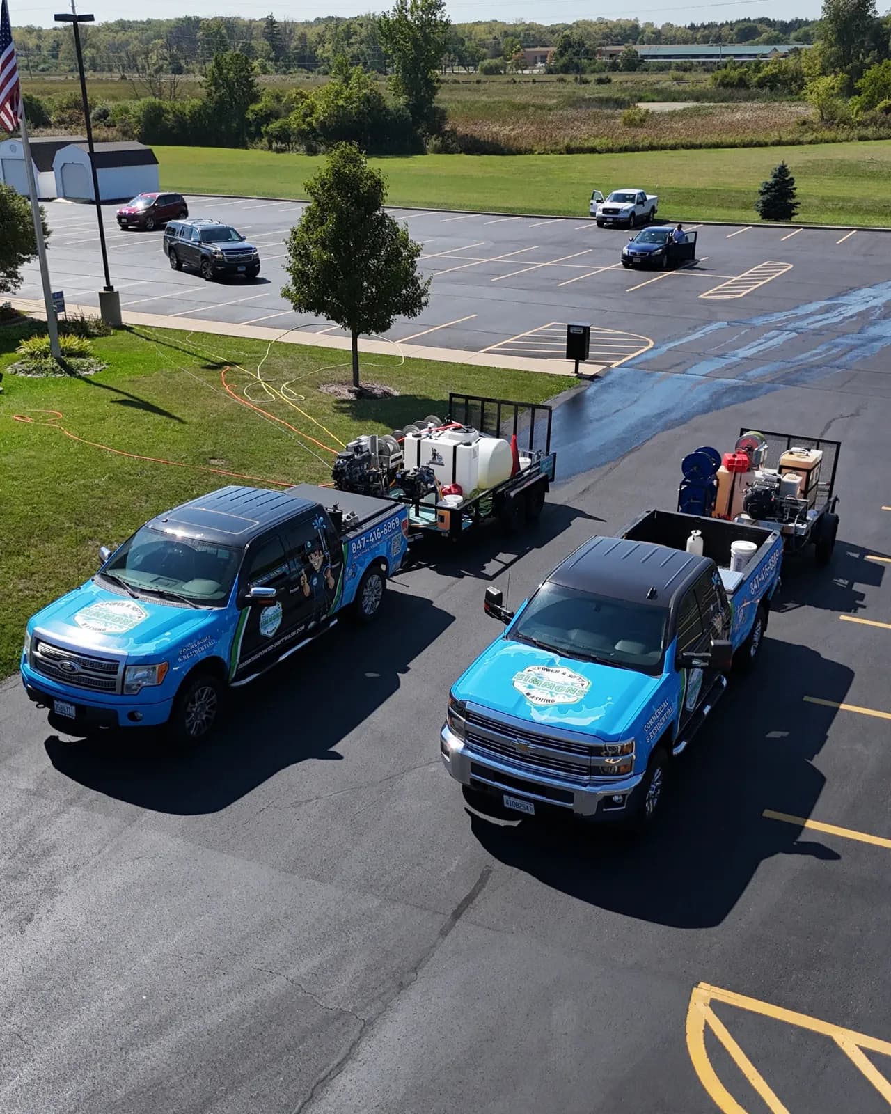 Two trucks and rigs at a commercial building, from above