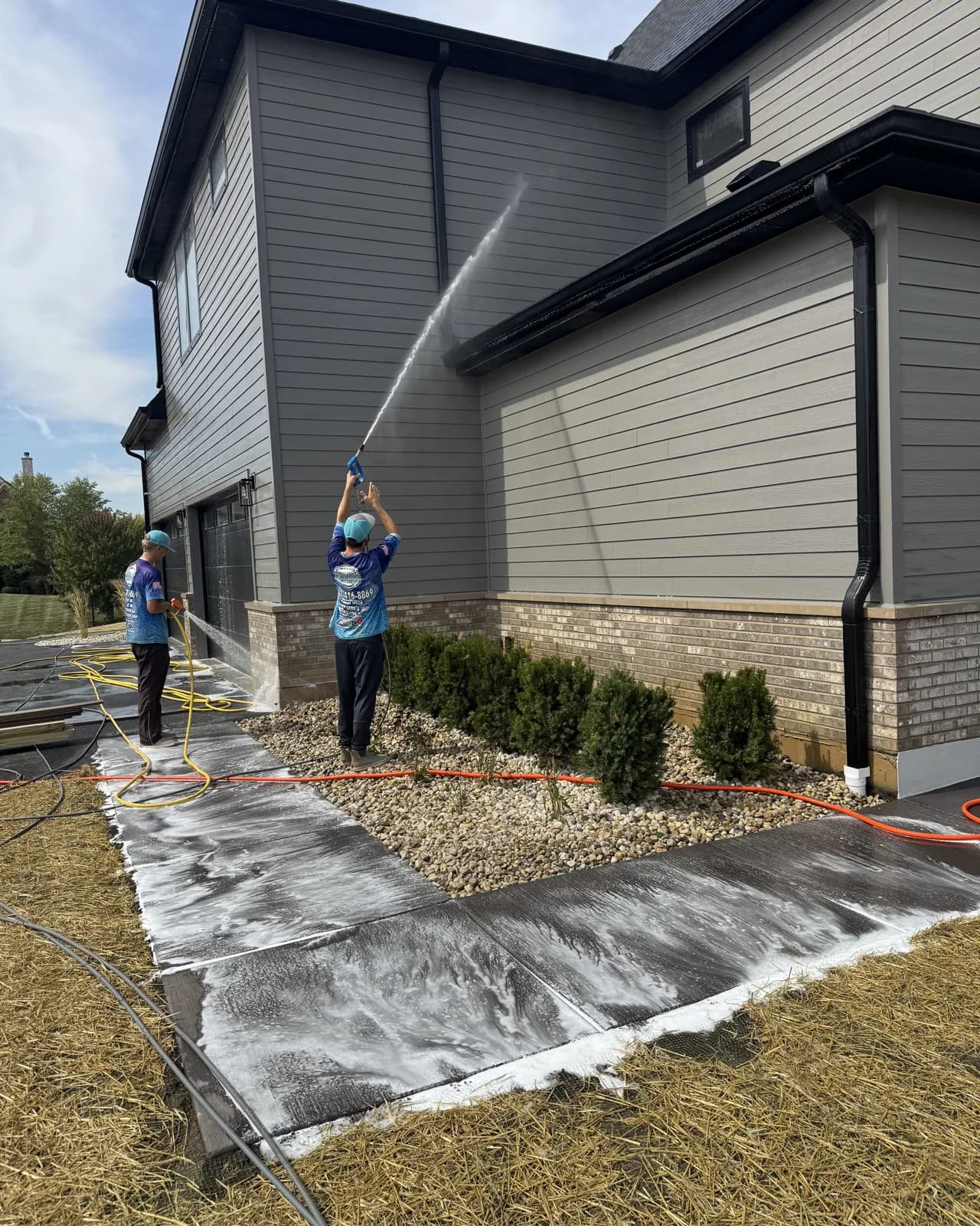 Soft washing a newly built home, foam on the walkway